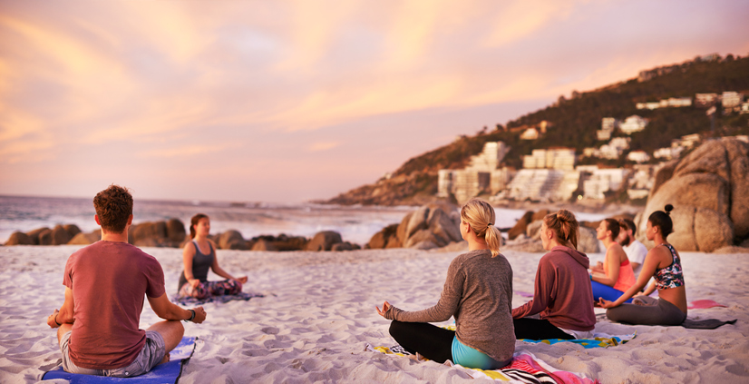 group of people on a beach yoga retreat